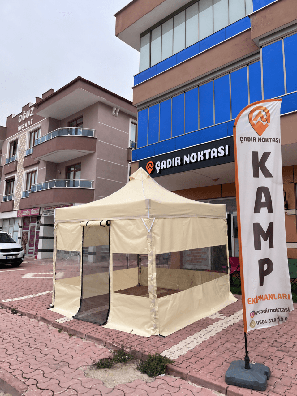 CADNOX Vistral Yarım Şeffaf krem kamp çadırı, mağaza önünde sol çapraz görünüm