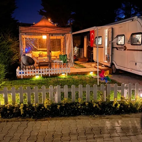 Gece ışıklandırılmış karavan yanında şeffaf gazebo çadır