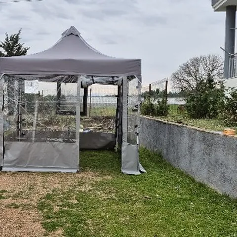 Bahçede kurulu gri şeffaf gazebo çadır