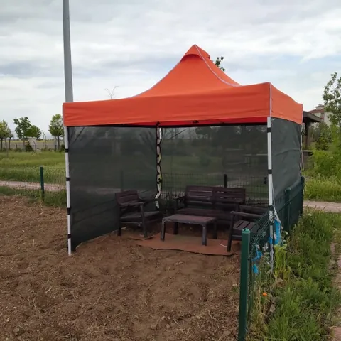 Bahçede turuncu tavanlı fileli gazebo çadır