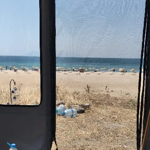 Çadırın içinden deniz ve plaj manzarası